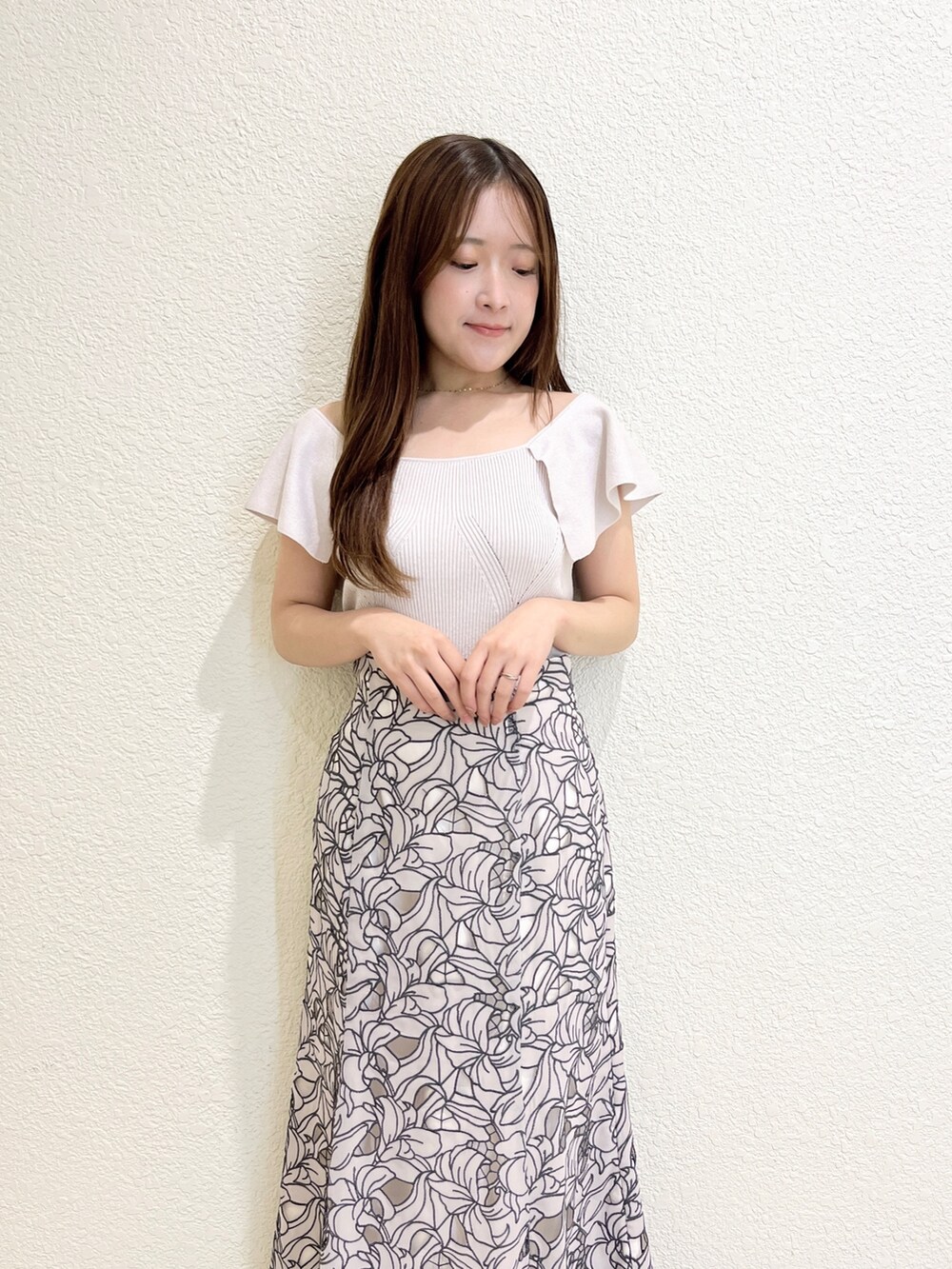 ピンク系のニット/セーター、ベージュ系のスカート、ブラック系のサンダルを着用したレディースの夏コーディネートの4枚目の写真