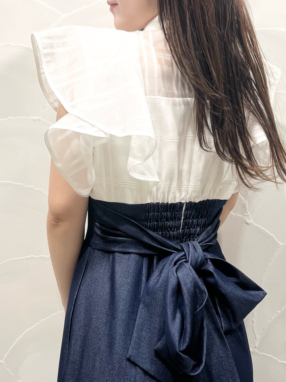 ホワイト系のワンピース、ホワイト系のトートバッグ、ブラウン系のサンダルを着用したレディースの春コーディネートの7枚目の写真