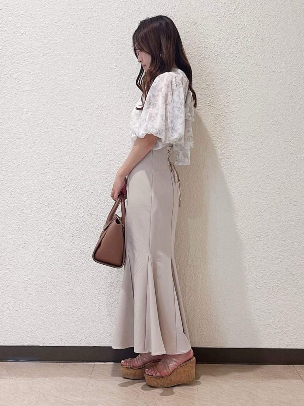 ベージュ系のシャツ/ブラウス、ベージュ系のスカート、ブラウン系のトートバッグを着用したレディースの春コーディネートの2枚目の写真