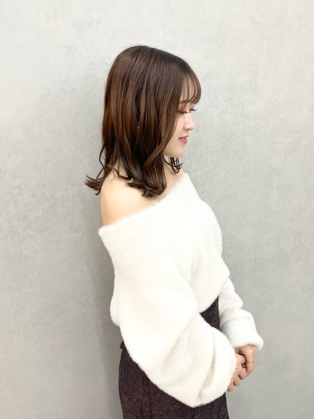 ホワイト系のニット/セーター、ブラウン系のスカート、ブラック系のブーツを着用したレディースの秋コーディネートの5枚目の写真