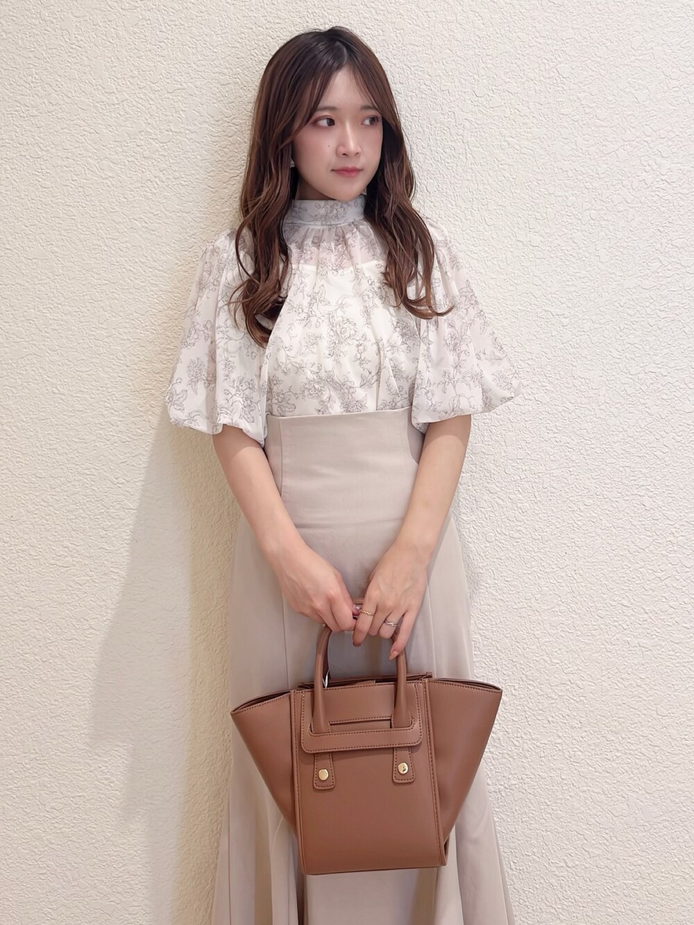 ベージュ系のシャツ/ブラウス、ベージュ系のスカート、ブラウン系のトートバッグを着用したレディースの春コーディネートの4枚目の写真