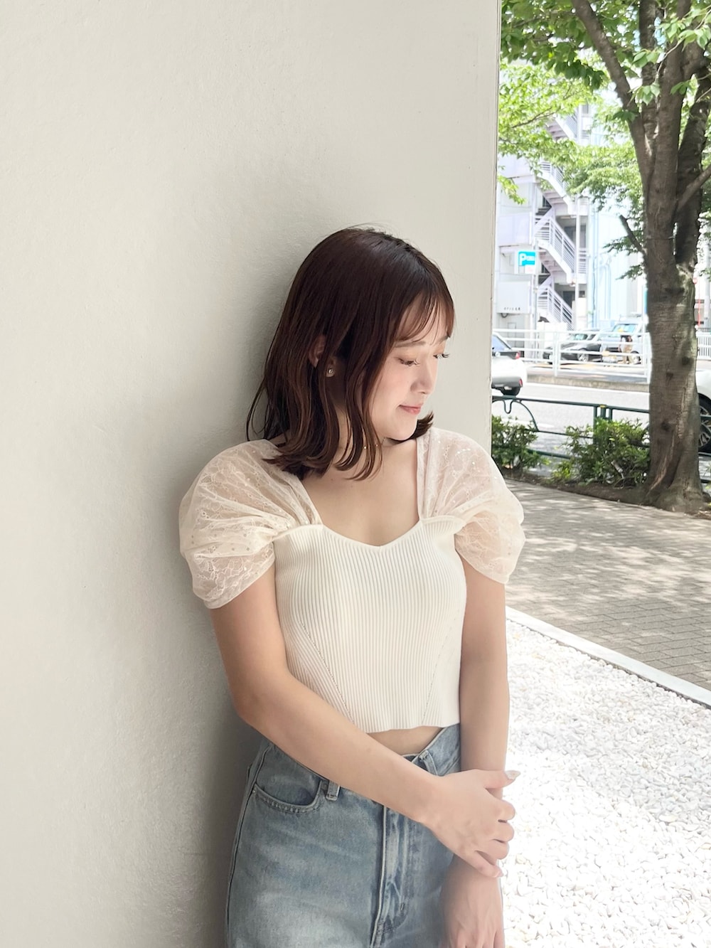 ホワイト系のニット/セーター、ブルー系のデニムパンツ、ホワイト系のトートバッグを着用したレディースの夏コーディネートの4枚目の写真