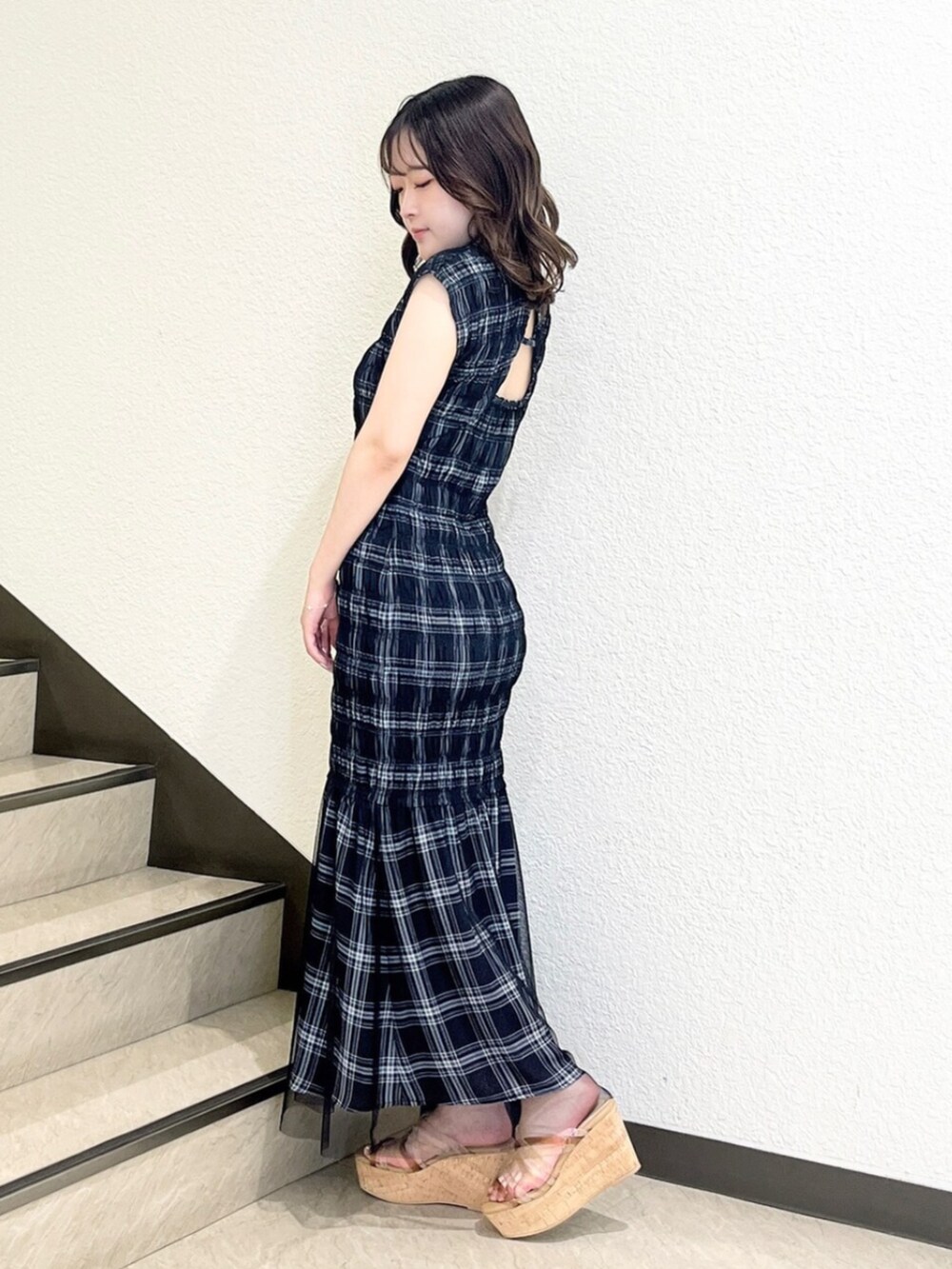 ブラック系のワンピース、ベージュ系のサンダルを着用したレディースの夏コーディネートの2枚目の写真