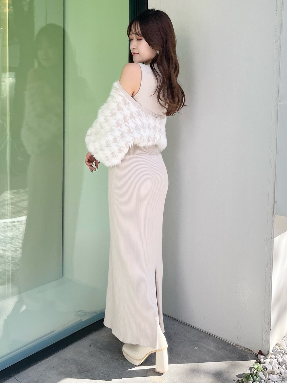 ホワイト系のムートンコート、ベージュ系のワンピース、ホワイト系のブーツを着用したレディースの秋コーディネートの5枚目の写真