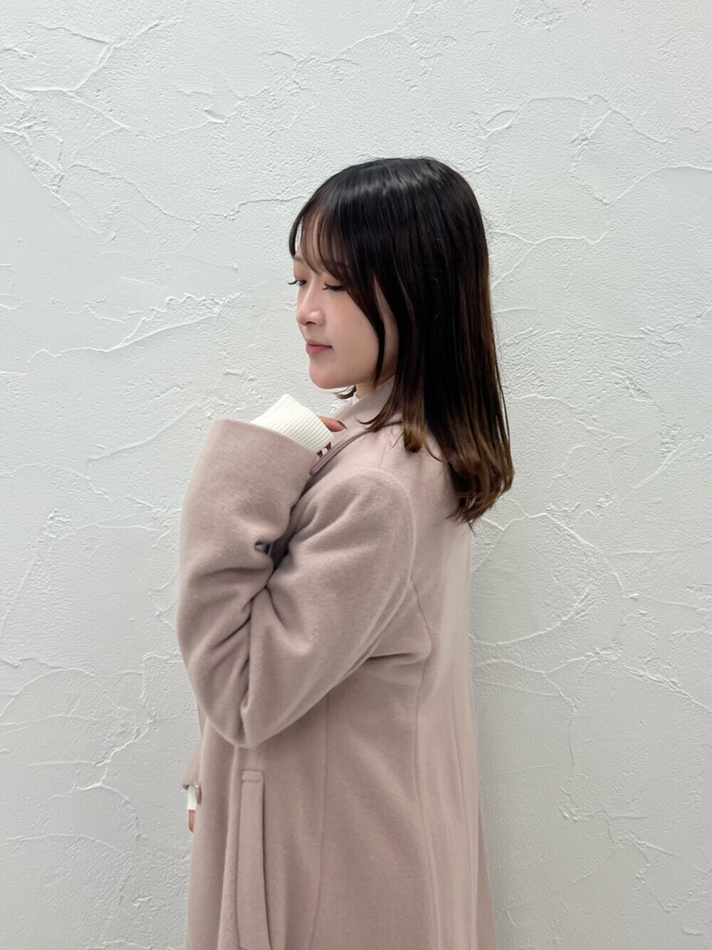 ベージュ系のその他アウター、ホワイト系のニット/セーター、ホワイト系のスカートを着用したレディースの秋コーディネートの5枚目の写真