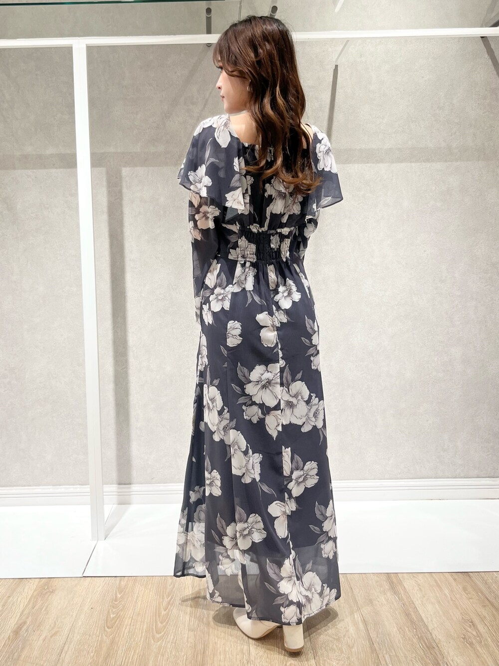 パープル系のチェスターコート、グレー系のワンピース、ホワイト系のショルダーバッグを着用したレディースの秋コーディネートの5枚目の写真