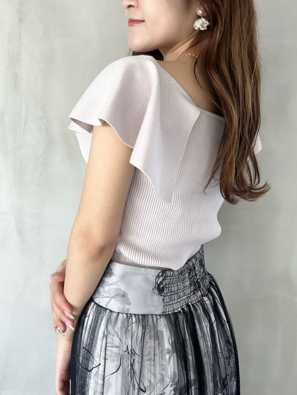 ブラック系のスカート、ピンク系のニット/セーター、ブラウン系のブーツを着用したレディースの春コーディネートの5枚目の写真