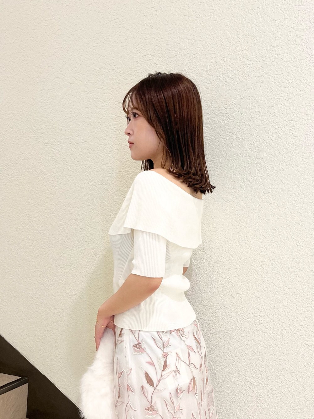 ホワイト系のニット/セーター、ホワイト系のスカート、ホワイト系のハンドバッグを着用したレディースの秋コーディネートの6枚目の写真