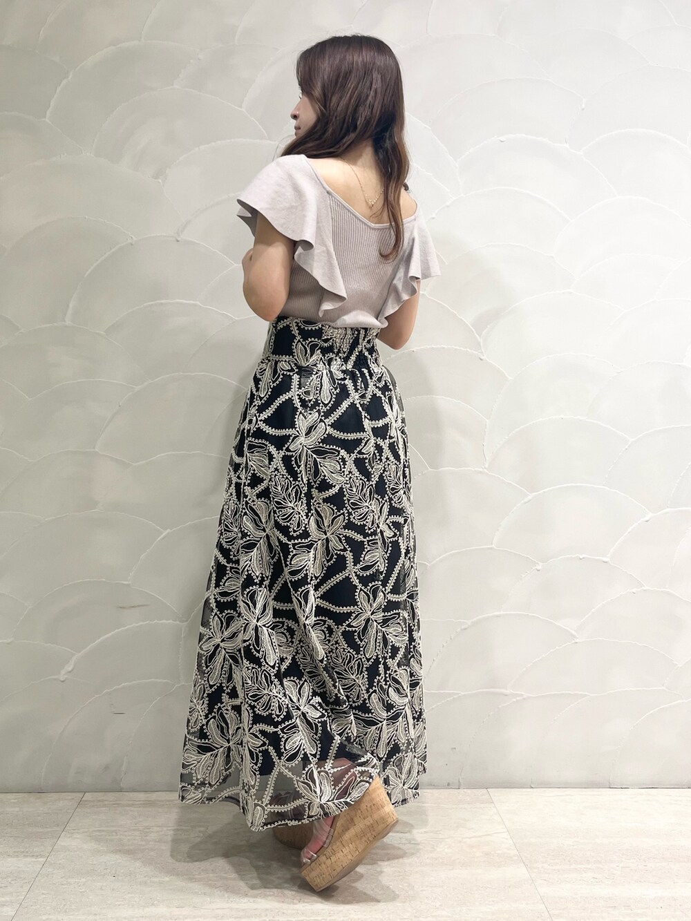 ブラック系のスカート、その他のサンダル、ベージュ系のニット/セーターを着用したレディースの夏コーディネートの3枚目の写真