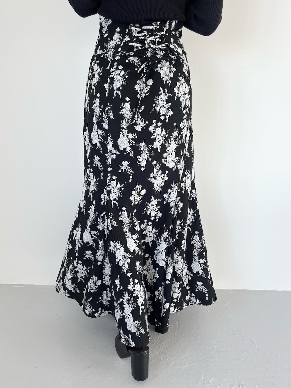 ブラック系のスカート、ブルー系のニット/セーター、ブラック系のブーツを着用したレディースの春コーディネートの5枚目の写真