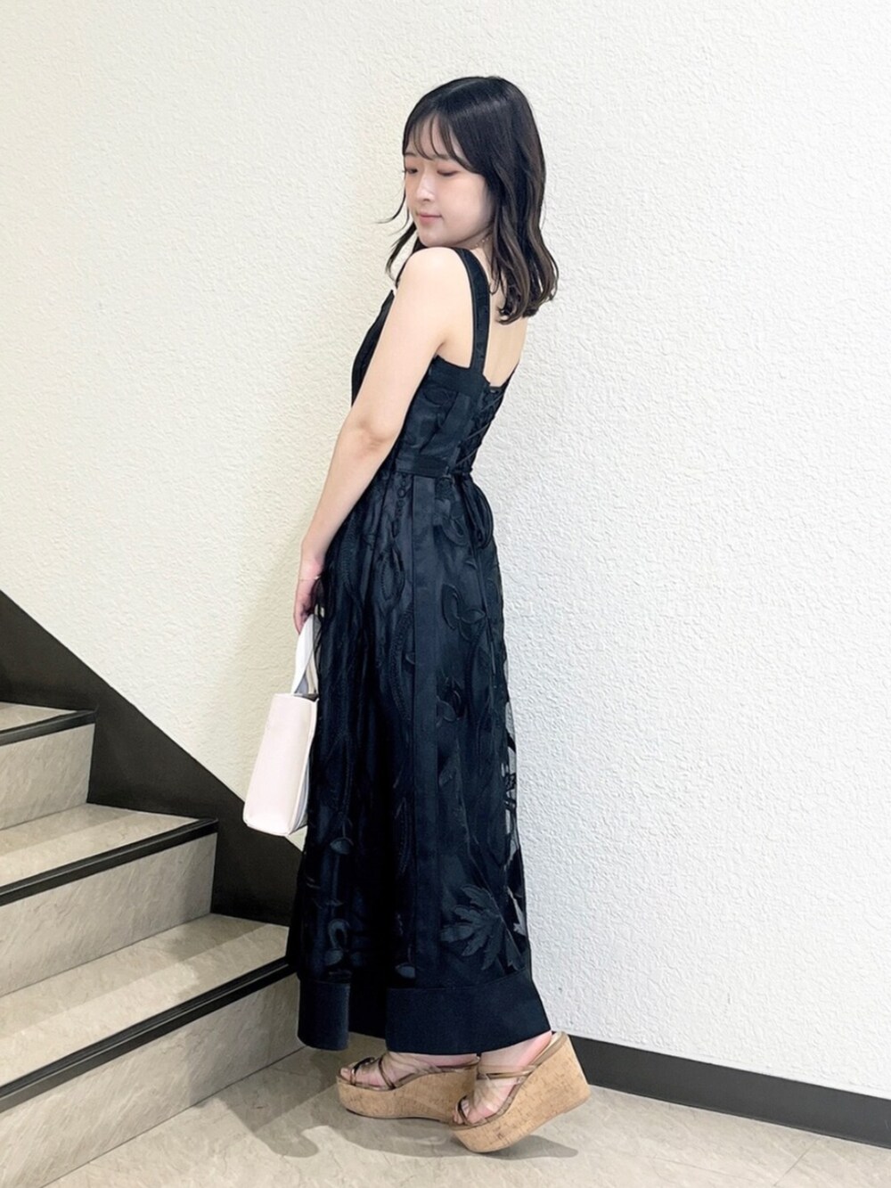 ブラック系のワンピース、ピンク系のトートバッグ、ブラウン系のサンダルを着用したレディースの夏コーディネートの2枚目の写真