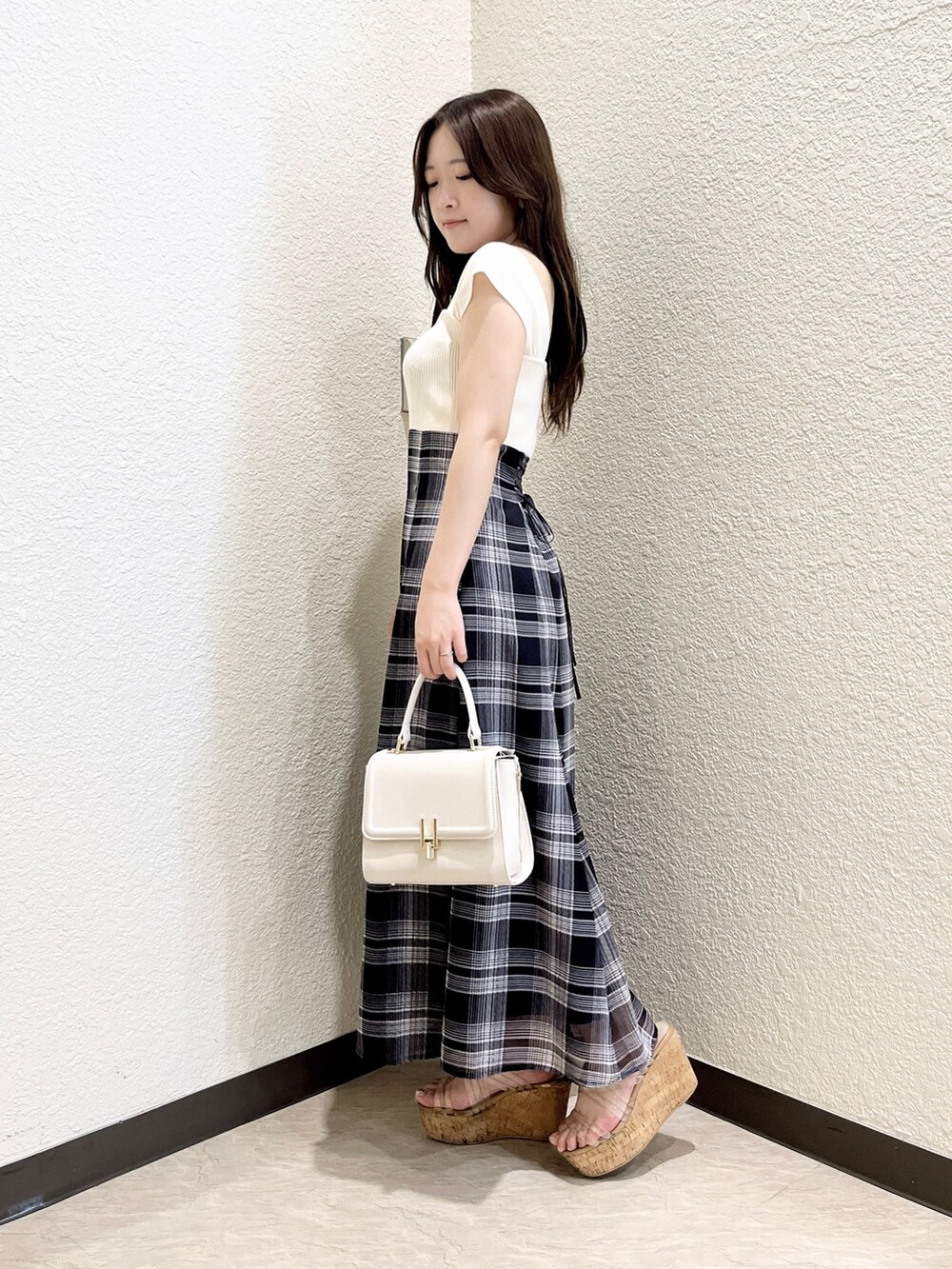 ホワイト系のワンピース、ホワイト系のハンドバッグ、その他のサンダルを着用したレディースの夏コーディネートの2枚目の写真