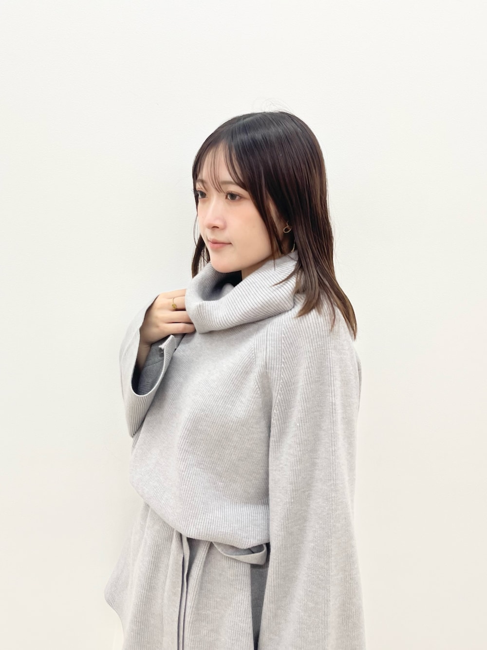 グレー系のニット/セーター、ホワイト系のスカートを着用したレディースの夏コーディネートの5枚目の写真