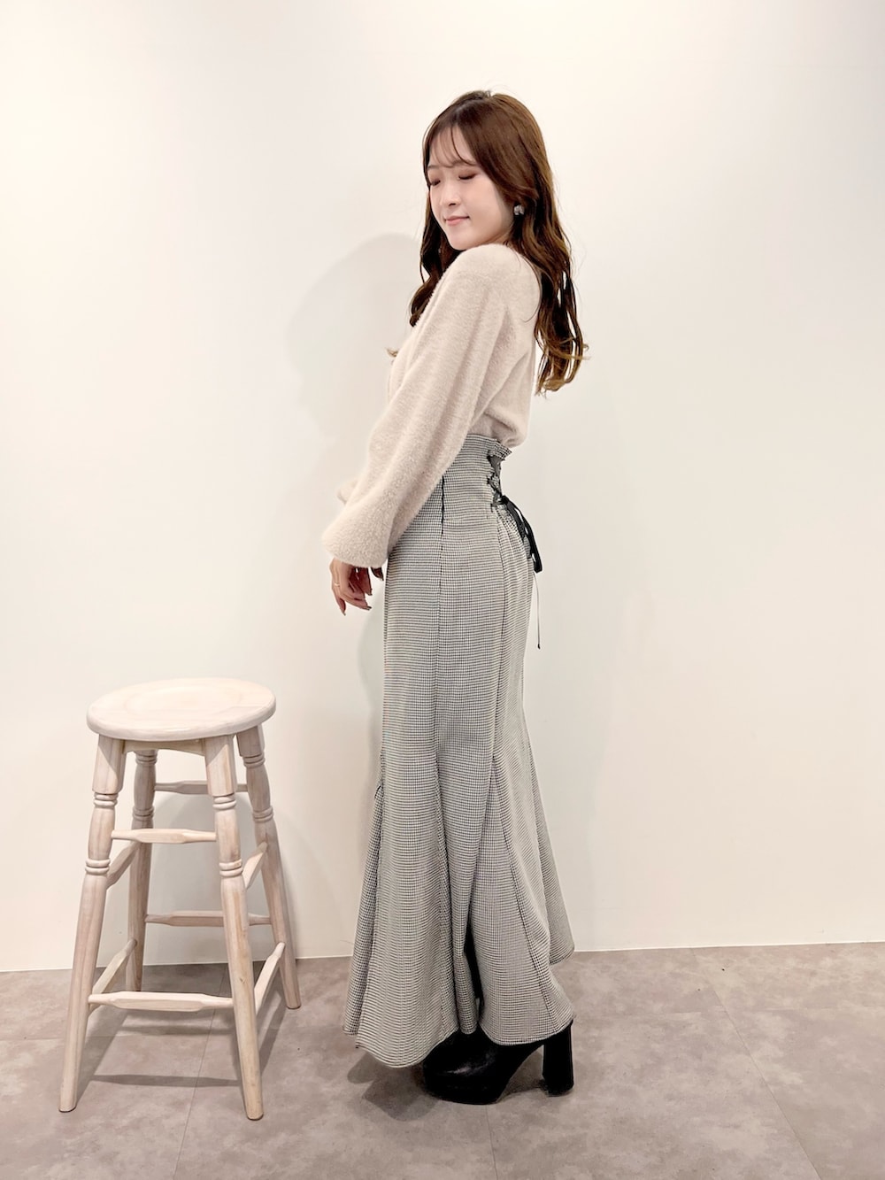 ベージュ系のカーディガン/ボレロ、その他のスカート、ブラック系のブーツを着用したレディースの冬コーディネートの2枚目の写真