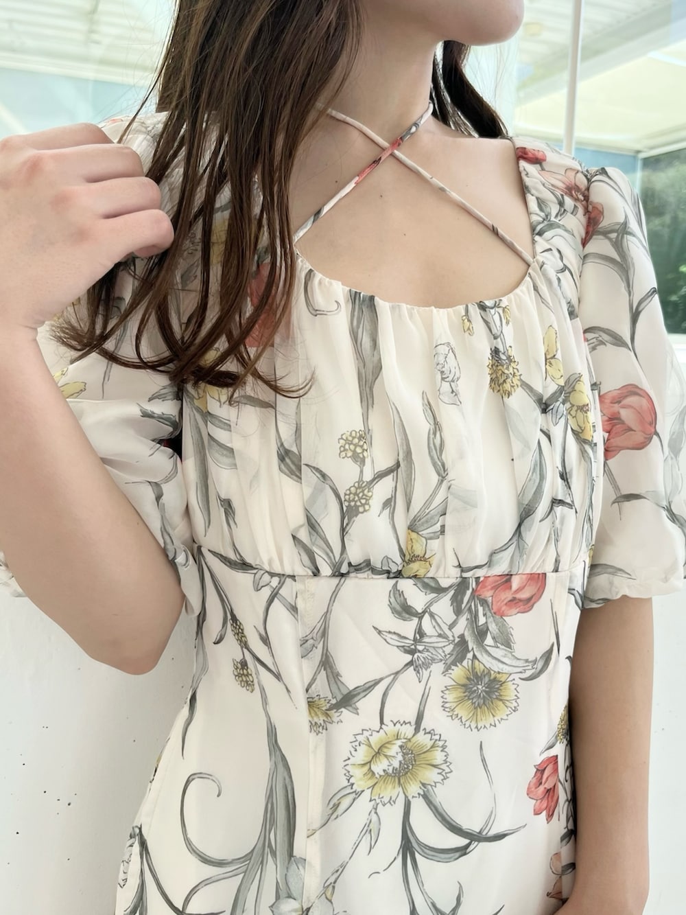 ホワイト系のワンピース、ブラウン系のハンドバッグ、ブラウン系のブーツを着用したレディースの夏コーディネートの3枚目の写真