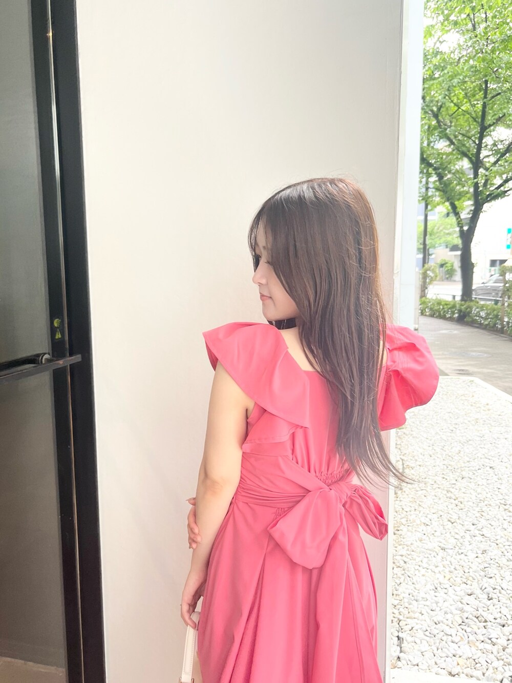 ピンク系のワンピース、ホワイト系のハンドバッグ、ホワイト系のパンプスを着用したレディースの夏コーディネートの4枚目の写真