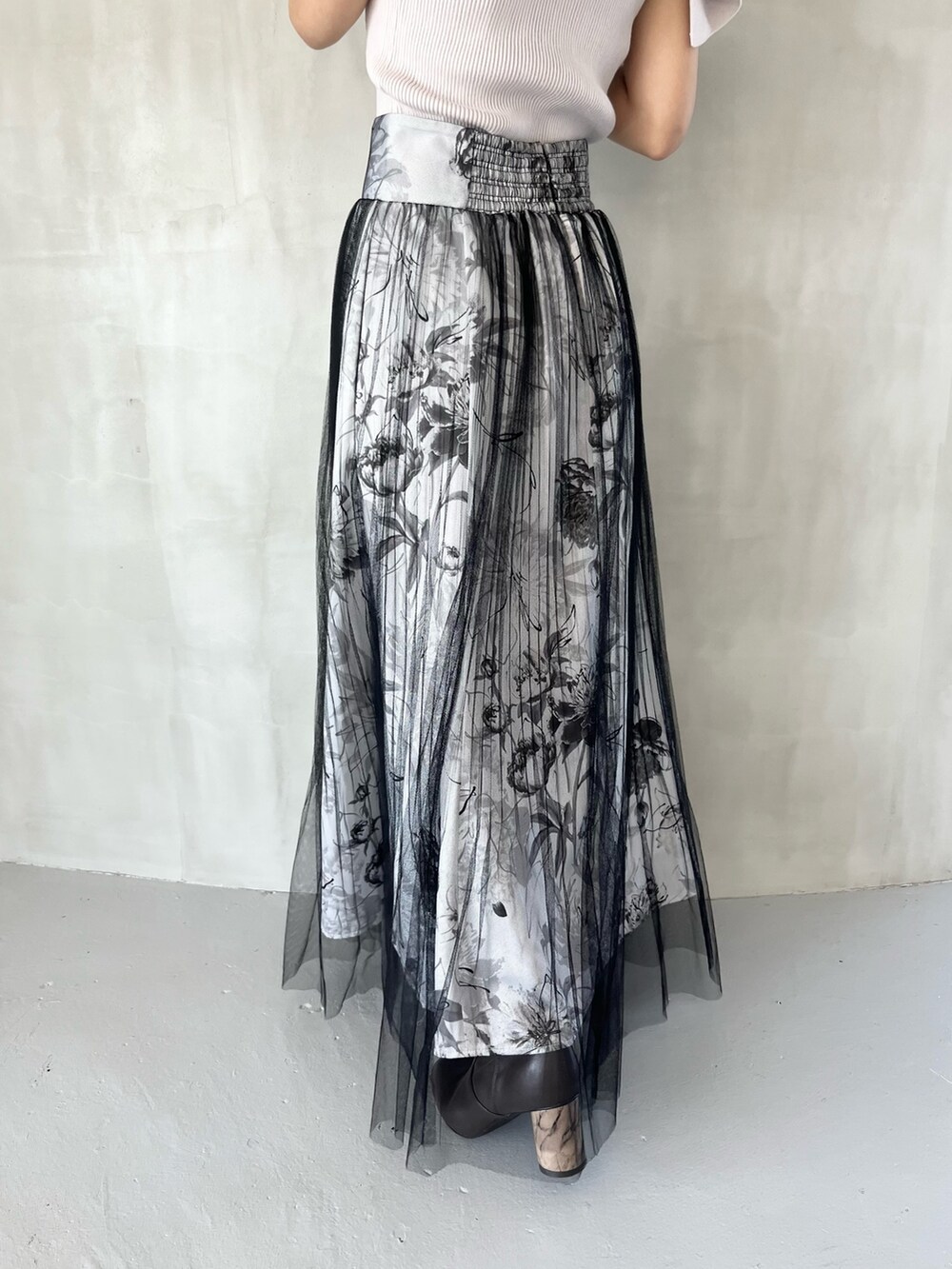 ブラック系のスカート、ピンク系のニット/セーター、ブラウン系のブーツを着用したレディースの春コーディネートの7枚目の写真