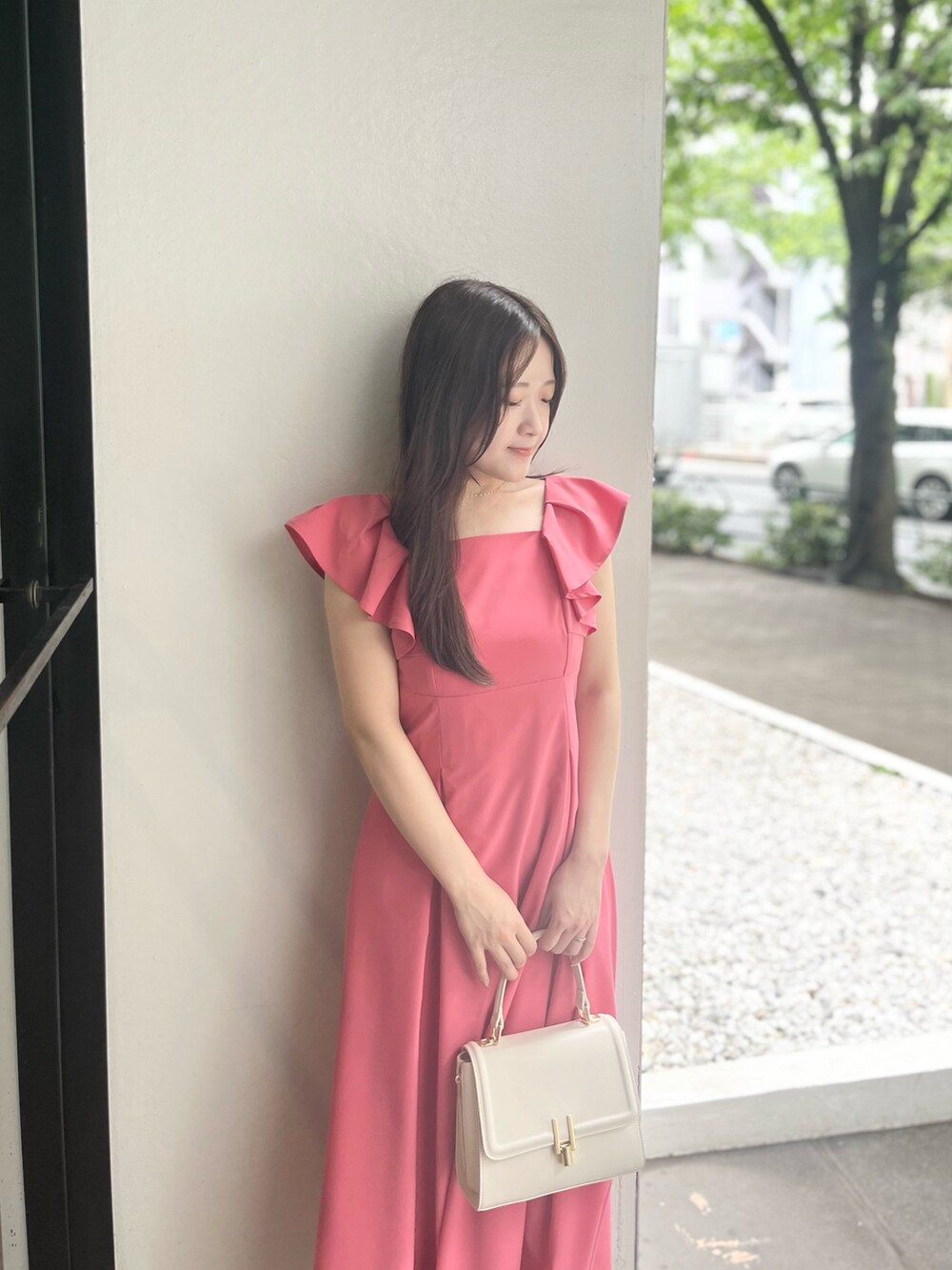 ピンク系のワンピース、ホワイト系のハンドバッグ、ホワイト系のパンプスを着用したレディースの夏コーディネートの6枚目の写真