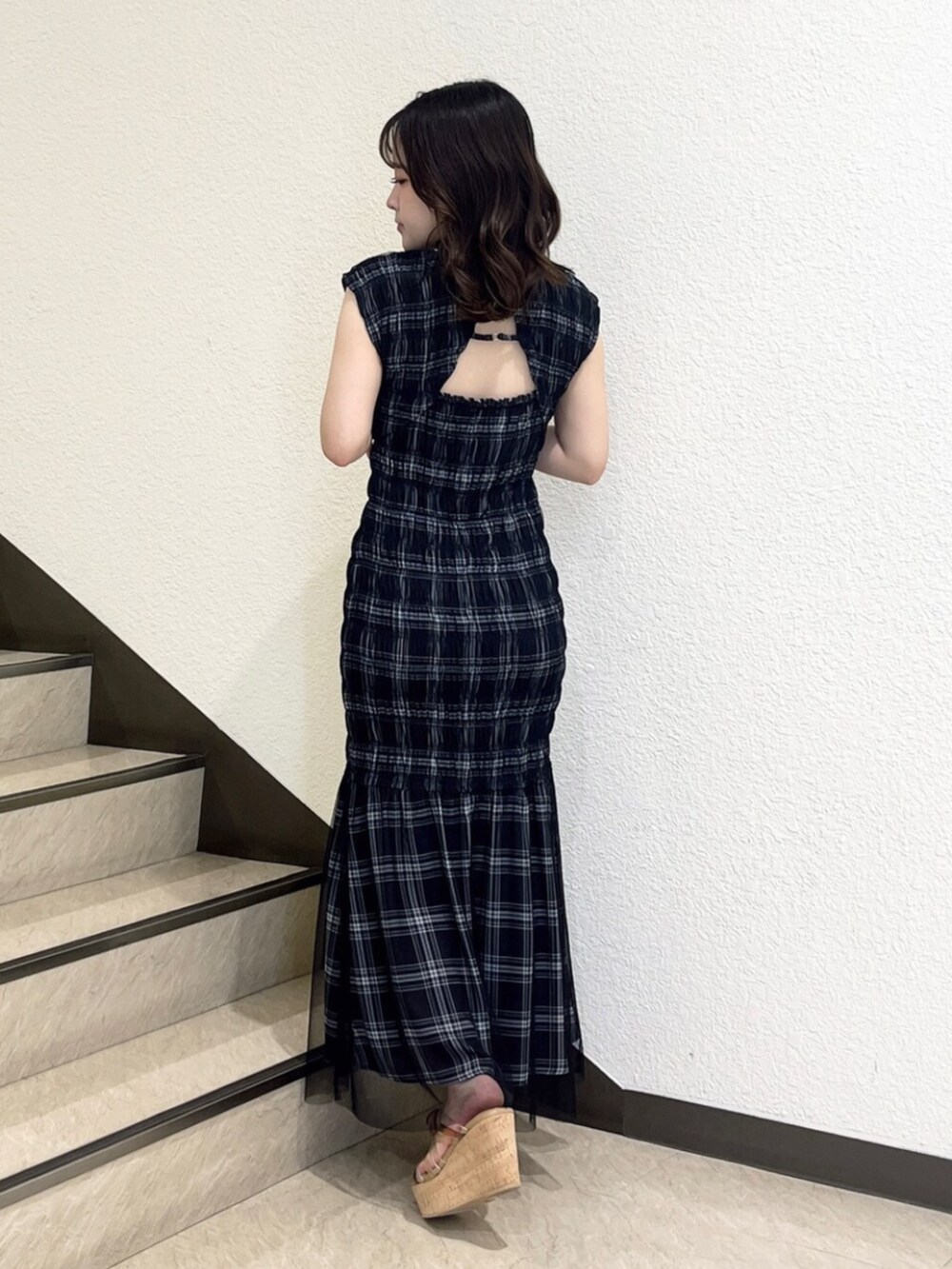 ブラック系のワンピース、ベージュ系のサンダルを着用したレディースの夏コーディネートの3枚目の写真