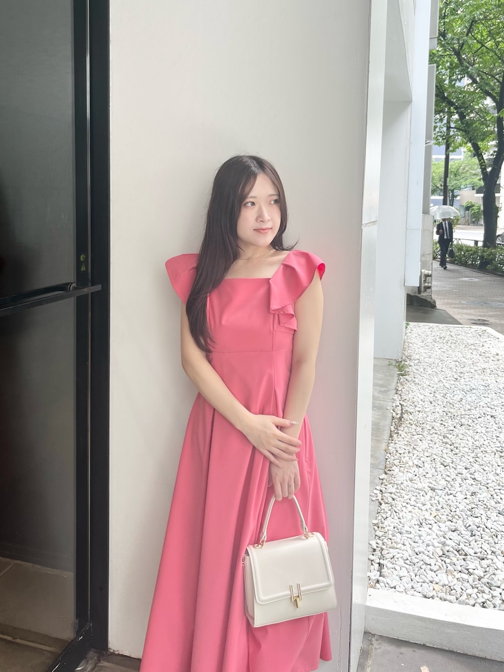 ピンク系のワンピース、ホワイト系のハンドバッグ、ホワイト系のパンプスを着用したレディースの夏コーディネートの5枚目の写真