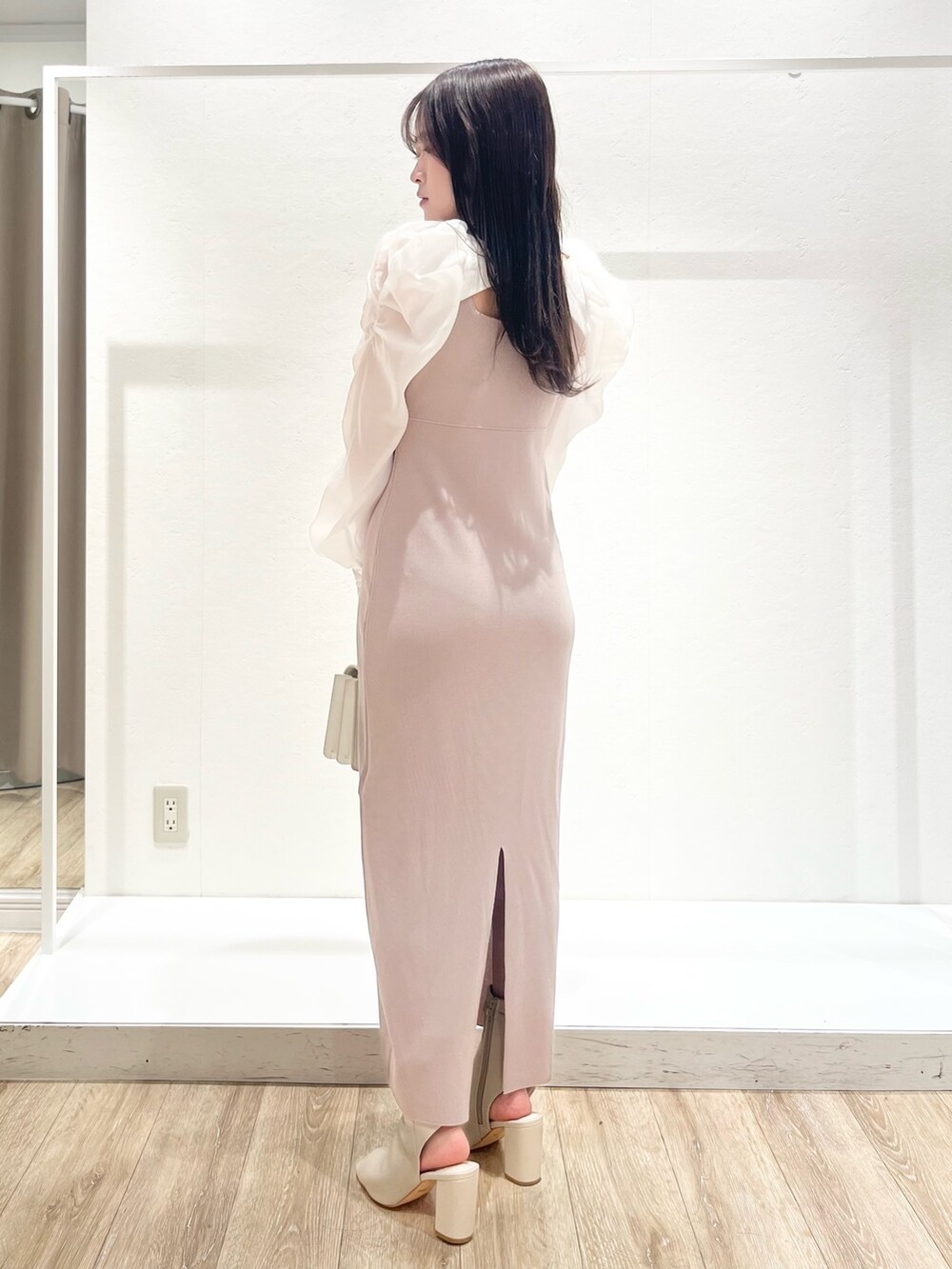 ホワイト系のトレンチコート、ベージュ系のワンピース、ホワイト系のショルダーバッグを着用したレディースの春コーディネートの6枚目の写真