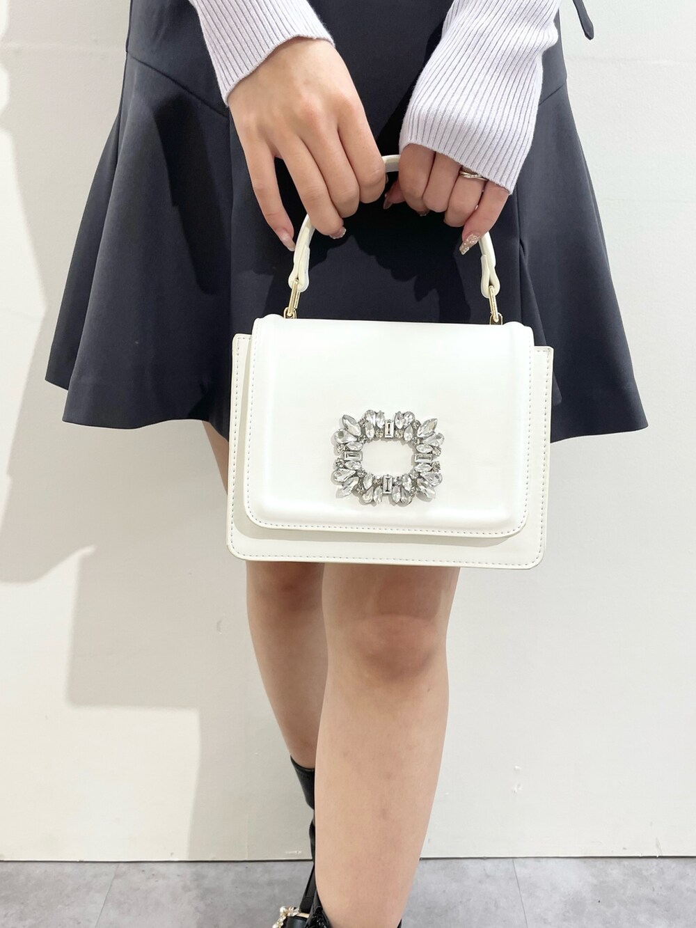 グレー系のその他パンツ、ホワイト系のショルダーバッグ、ブラック系のブーツを着用したレディースの冬コーディネートの3枚目の写真