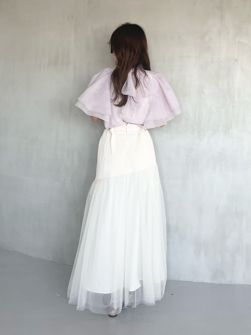 パープル系のシャツ/ブラウス、ホワイト系のスカート、ブラウン系のブーツを着用したレディースの春コーディネートの3枚目の写真