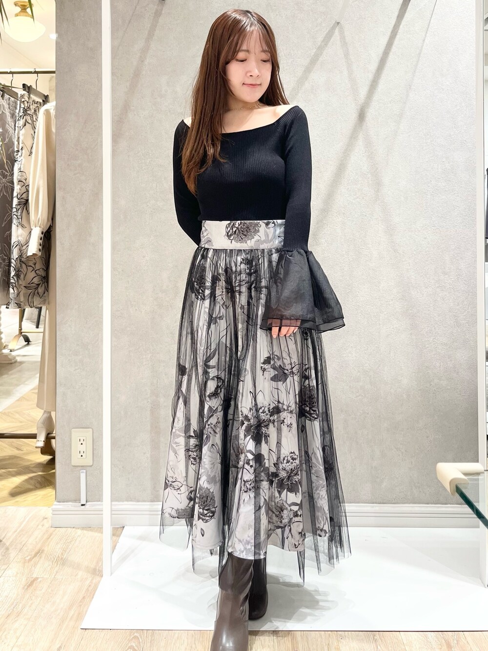 ホワイト系のトレンチコート、ブラック系のスカート、ブラック系のニット/セーターを着用したレディースの冬コーディネートの4枚目の写真