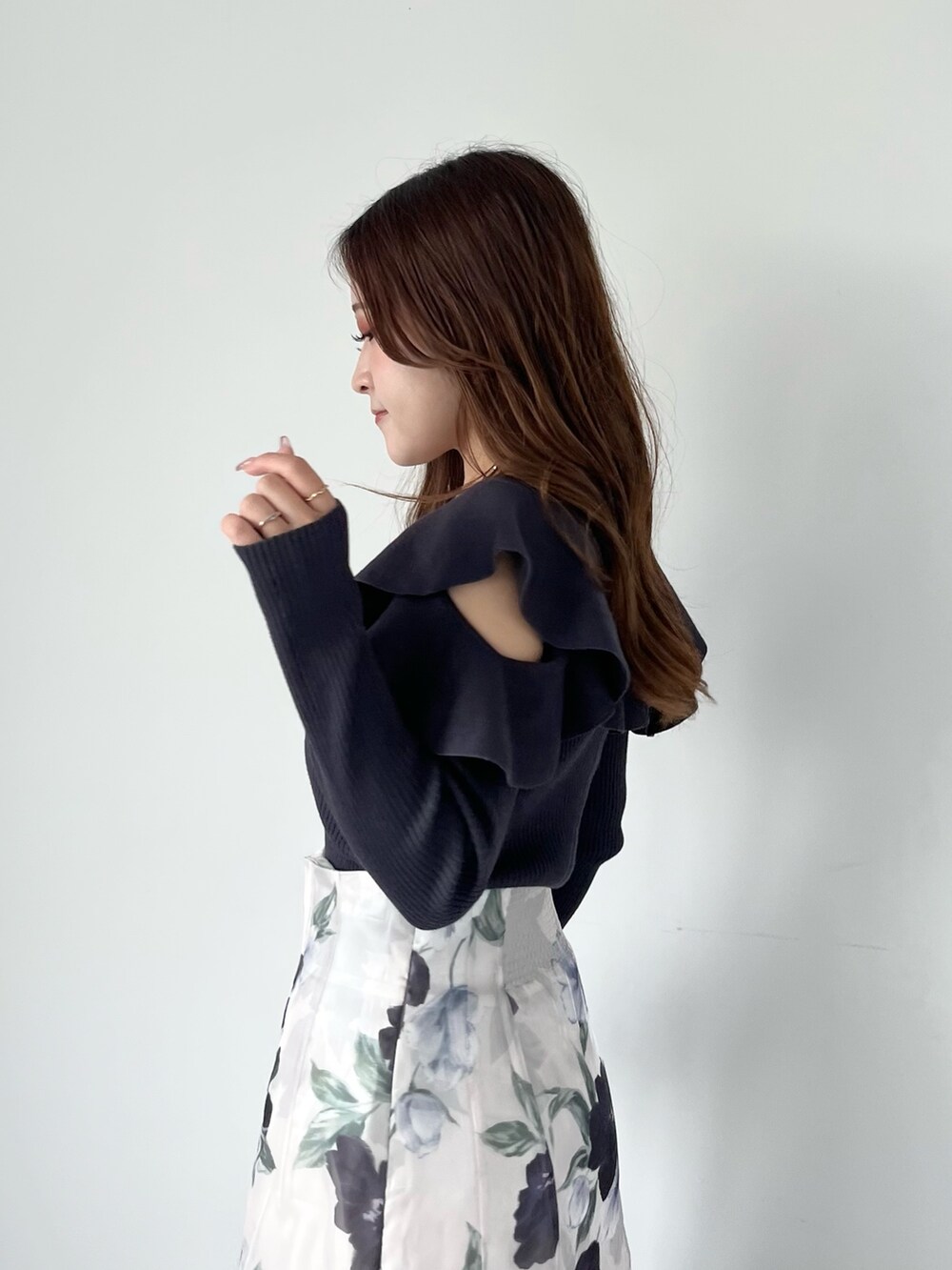 ブルー系のスカート、グレー系のニット/セーター、ホワイト系のブーツを着用したレディースの秋コーディネートの7枚目の写真