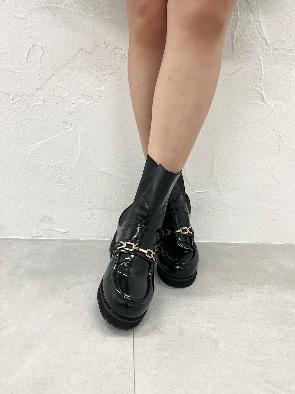 ホワイト系のノーカラージャケット、ブラック系のスカート、ブラック系のブーツを着用したレディースの秋コーディネートの4枚目の写真