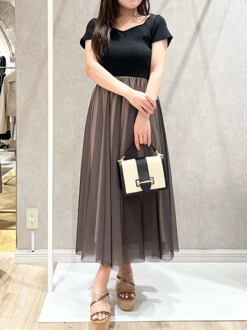 ブラック系のワンピース、ブラック系のハンドバッグ、ブラック系のサンダルを着用したレディースの春コーディネートの7枚目の写真