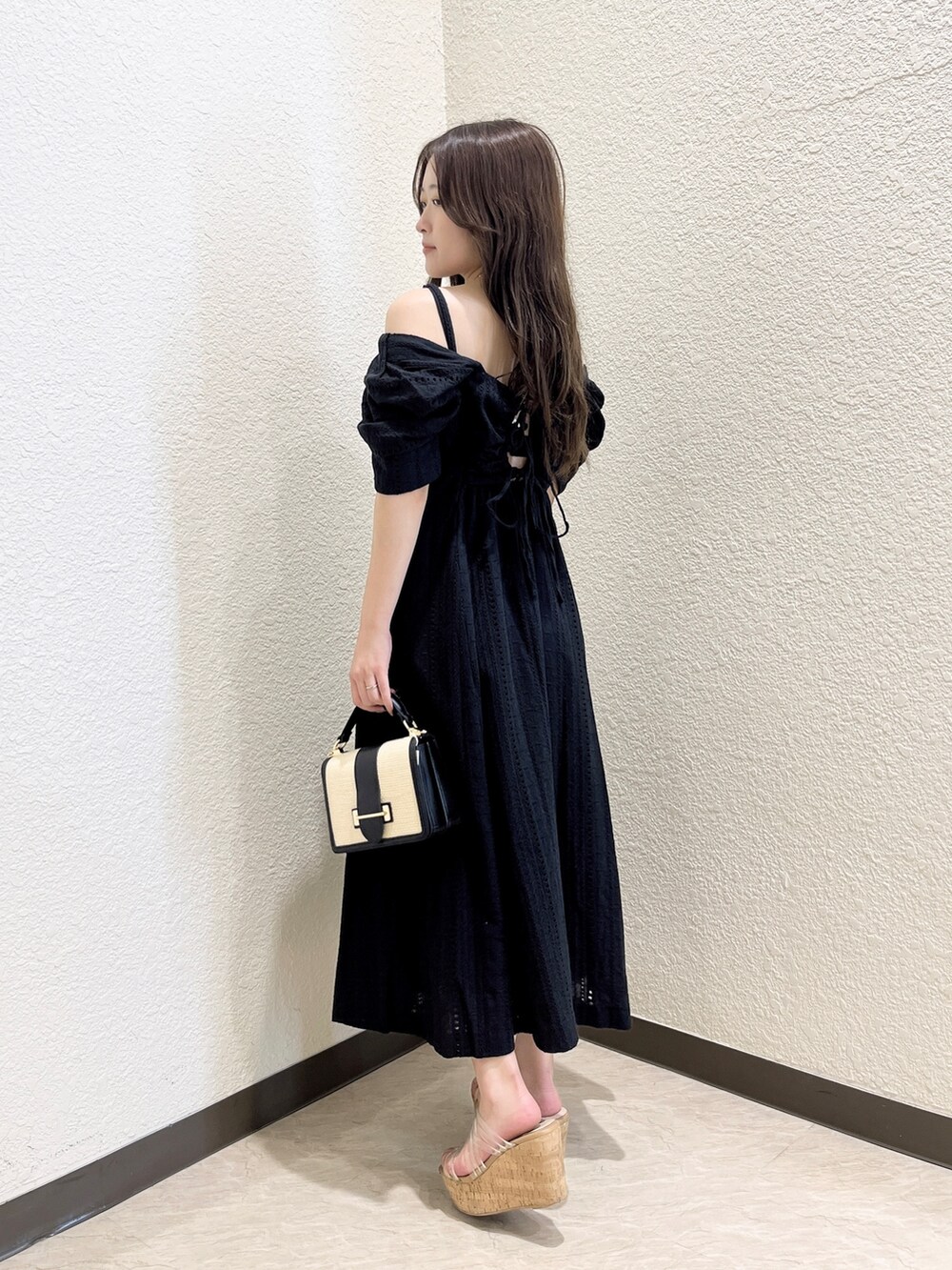 ブラック系のワンピース、その他のサンダル、ブラック系のハンドバッグを着用したレディースの夏コーディネートの3枚目の写真