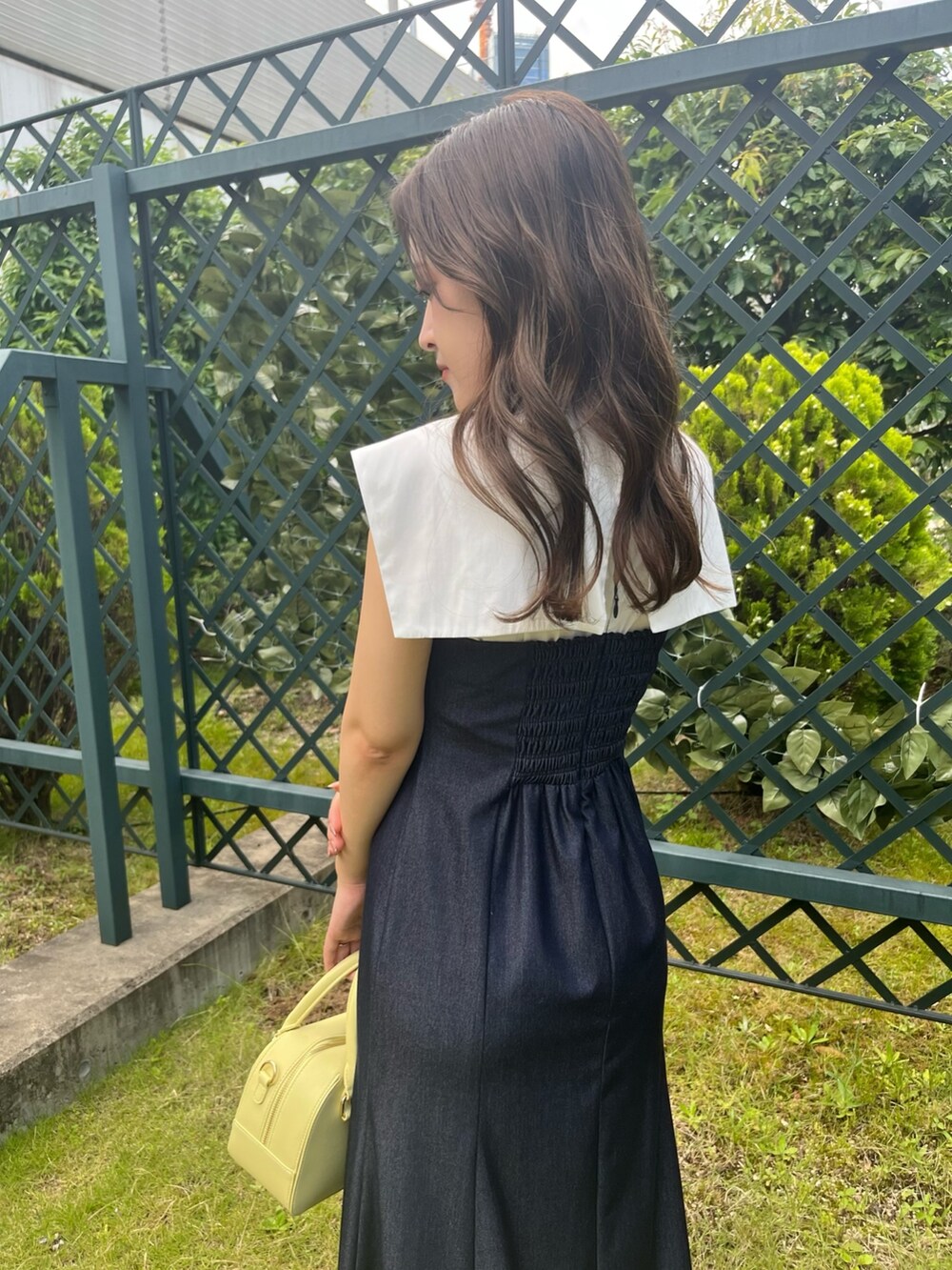 ブルー系のワンピース、イエロー系のボストンバッグ、イエロー系のサンダルを着用したレディースの夏コーディネートの5枚目の写真