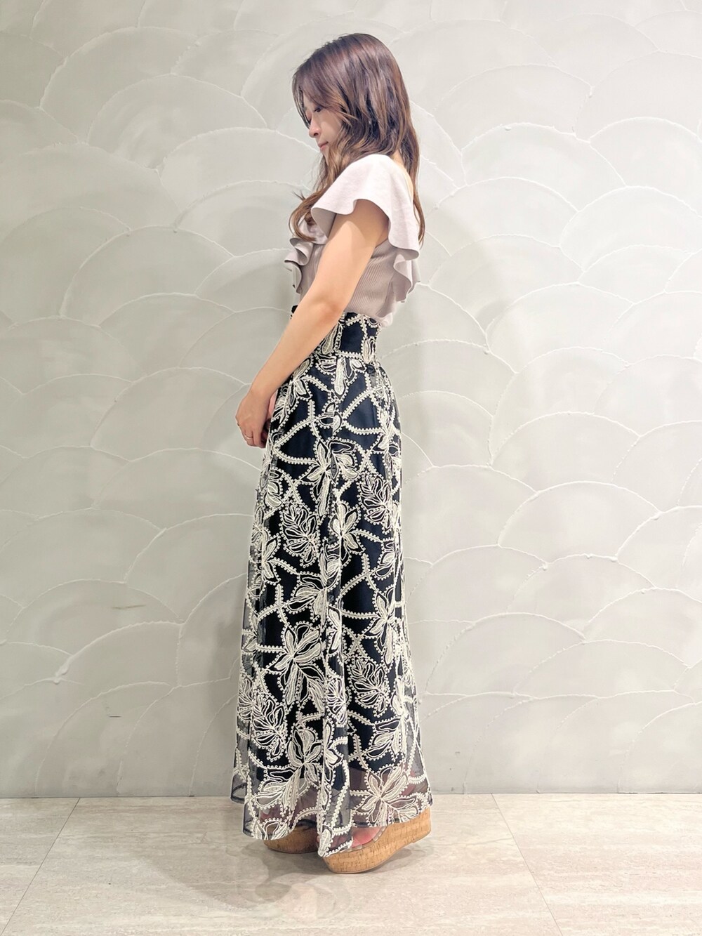 ブラック系のスカート、その他のサンダル、ベージュ系のニット/セーターを着用したレディースの夏コーディネートの2枚目の写真