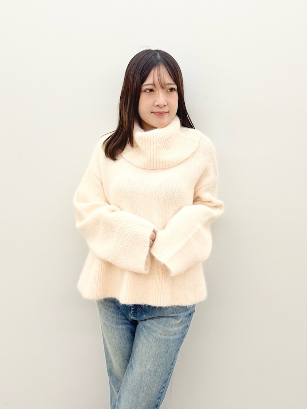 ピンク系のニット/セーター、ブルー系のデニムパンツを着用したレディースの秋コーディネートの4枚目の写真