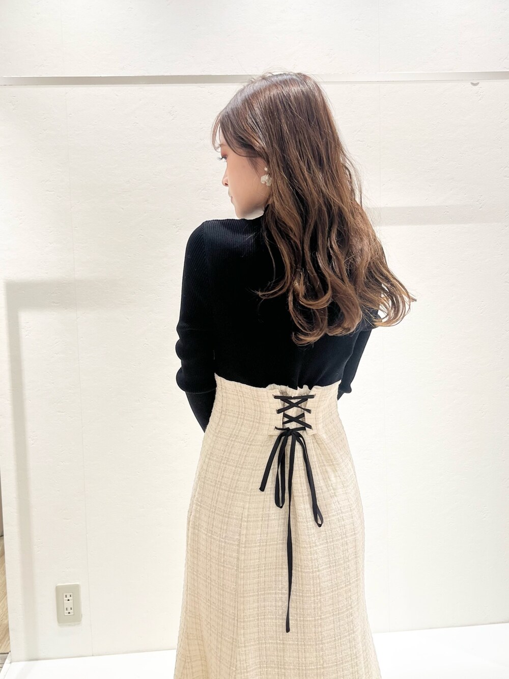 ホワイト系のワンピース、ブラウン系のチェスターコート、ホワイト系のハンドバッグを着用したレディースの秋コーディネートの5枚目の写真