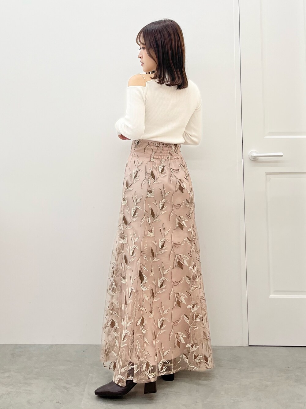 ピンク系のスカート、ホワイト系のニット/セーター、ホワイト系のその他アウターを着用したレディースの秋コーディネートの7枚目の写真