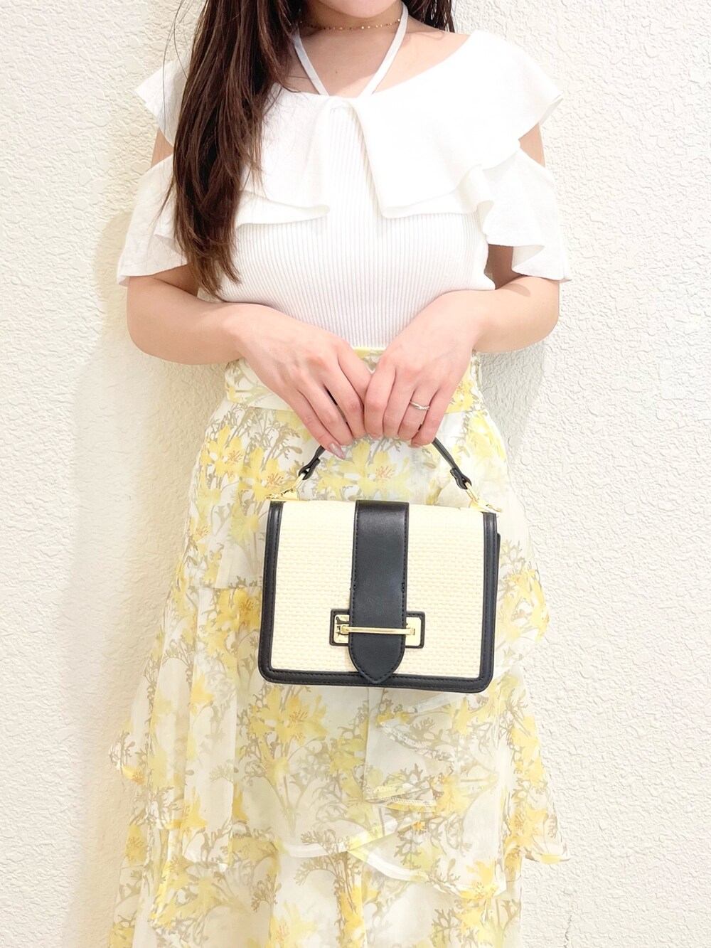 ホワイト系のニット/セーター、イエロー系のスカート、その他のサンダルを着用したレディースの春コーディネートの4枚目の写真
