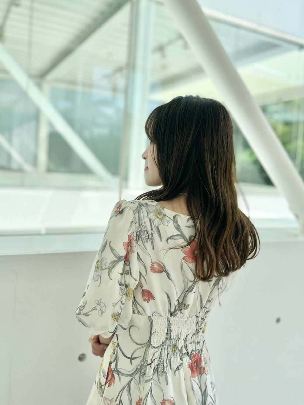 ホワイト系のワンピース、ブラウン系のハンドバッグ、ブラウン系のブーツを着用したレディースの夏コーディネートの4枚目の写真