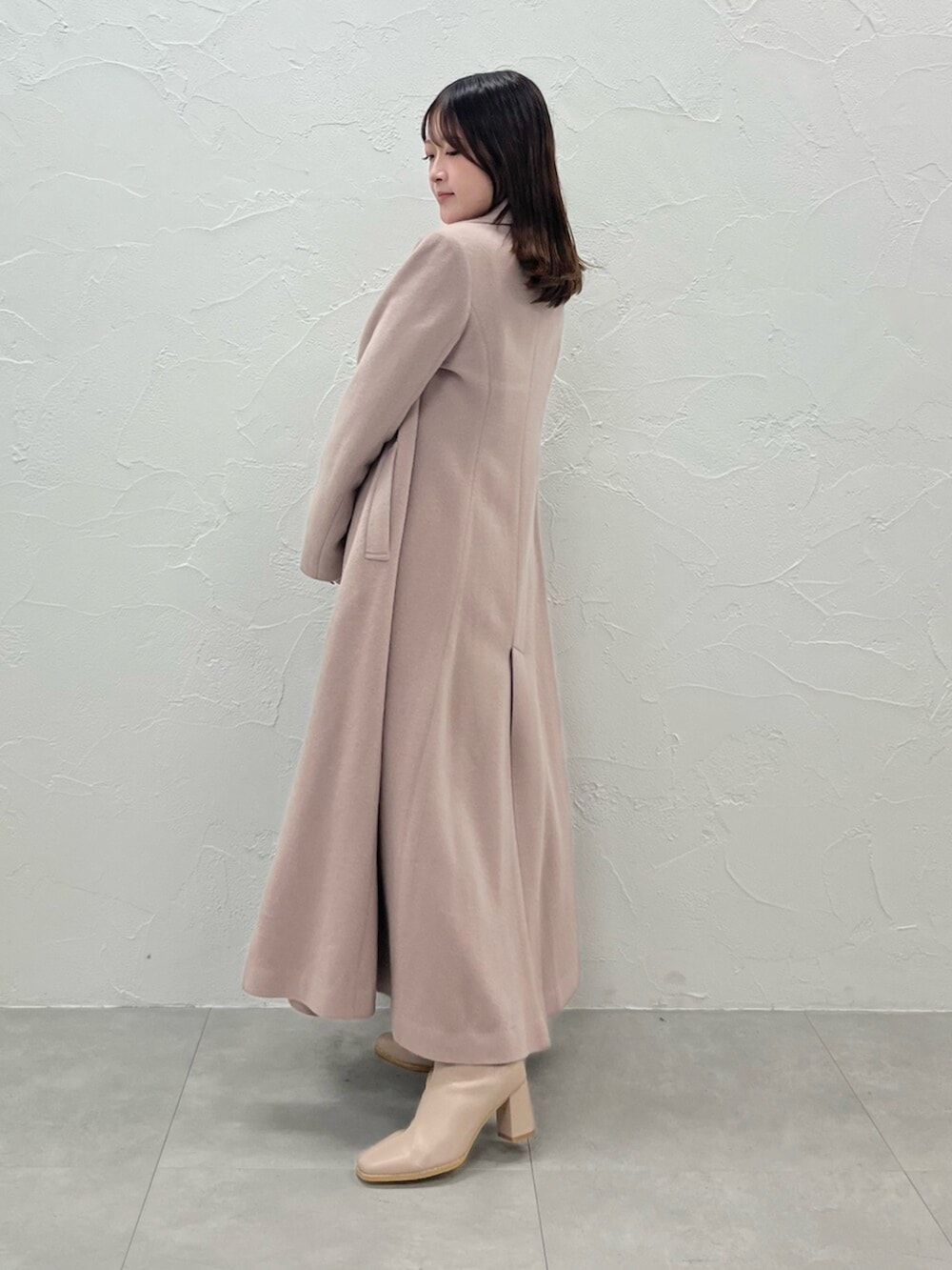 ベージュ系のその他アウター、ホワイト系のニット/セーター、ホワイト系のスカートを着用したレディースの秋コーディネートの2枚目の写真