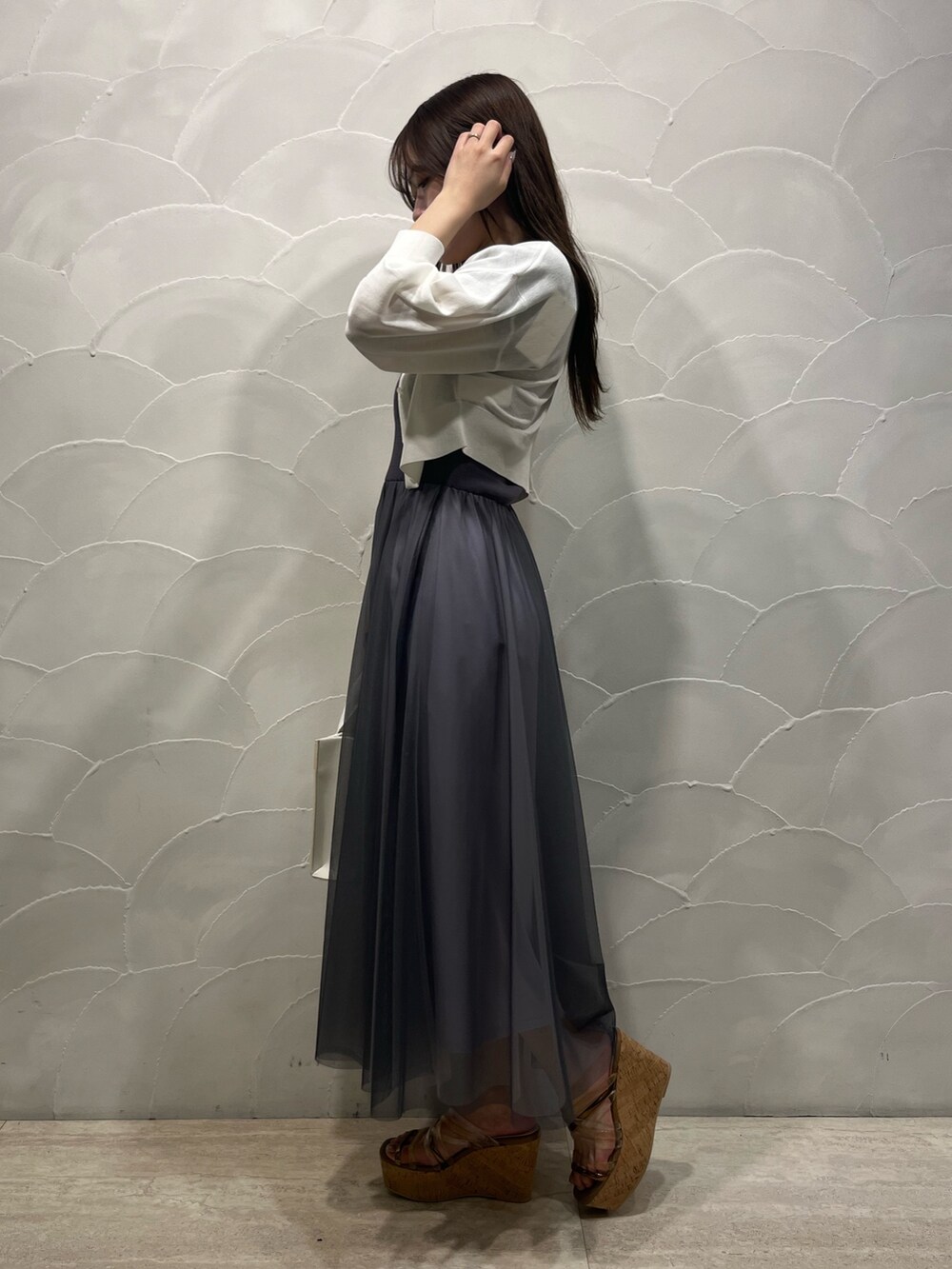 グレー系のワンピース、ホワイト系のトートバッグ、ホワイト系のカーディガン/ボレロを着用したレディースの春コーディネートの4枚目の写真