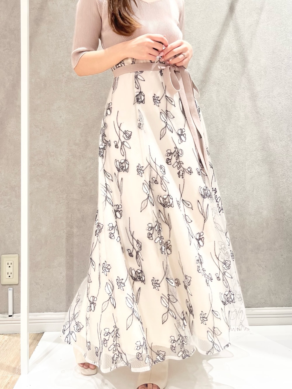 ベージュ系のワンピース、ホワイト系のライダースジャケット、ホワイト系のブーツを着用したレディースの春コーディネートの4枚目の写真