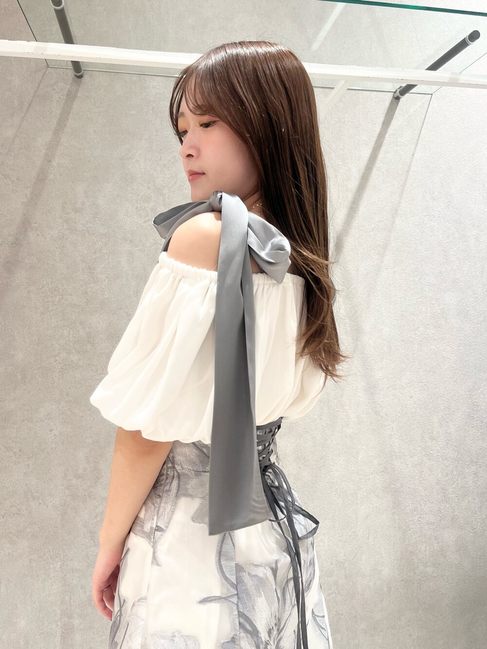 ホワイト系のシャツ/ブラウス、グレー系のスカート、ホワイト系のブーツを着用したレディースの春コーディネートの6枚目の写真