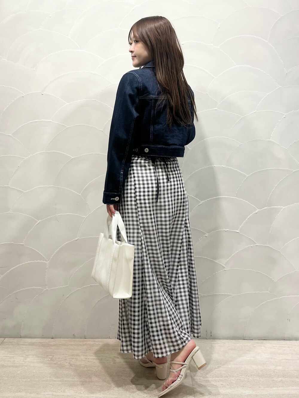 ブルー系のデニムジャケット、ピンク系のニット/セーター、その他のスカートを着用したレディースの春コーディネートの3枚目の写真