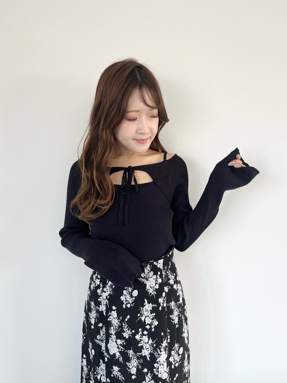 ブラック系のスカート、ブルー系のニット/セーター、ブラック系のブーツを着用したレディースの春コーディネートの4枚目の写真