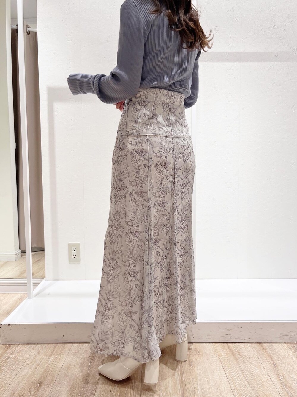 ホワイト系のスカート、ブルー系のニット/セーター、ホワイト系のブーツを着用したレディースの秋コーディネートの3枚目の写真