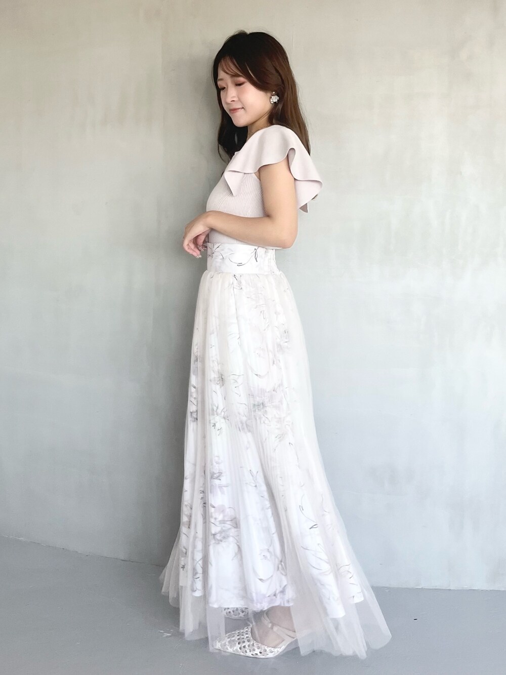 ピンク系のスカート、ピンク系のニット/セーター、その他のパンプスを着用したレディースの冬コーディネートの2枚目の写真