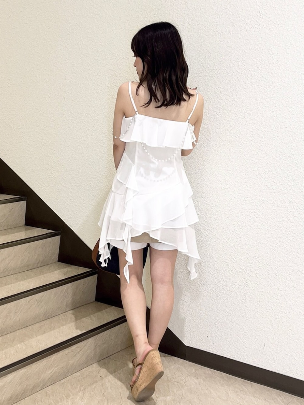 ブラウン系のサンダル、ホワイト系のシャツ/ブラウス、ベージュ系のスカートを着用したレディースの夏コーディネートの3枚目の写真