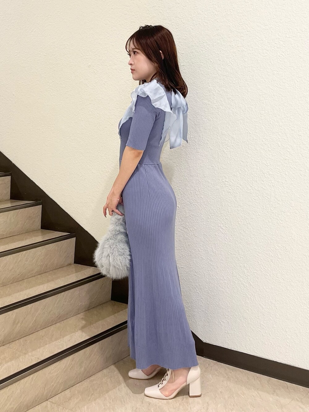 ブルー系のワンピース、グレー系のハンドバッグ、ホワイト系のブーツを着用したレディースの夏コーディネートの2枚目の写真