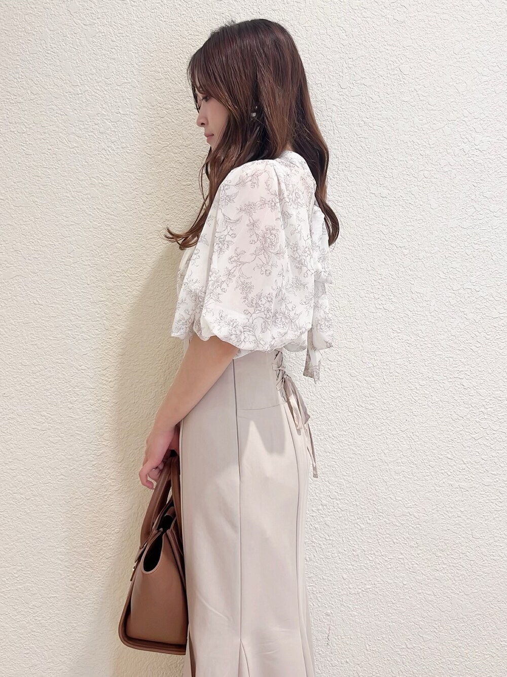 ベージュ系のシャツ/ブラウス、ベージュ系のスカート、ブラウン系のトートバッグを着用したレディースの春コーディネートの5枚目の写真